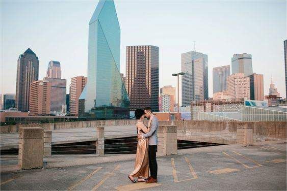 an engaged couple standing in front of the city skyline