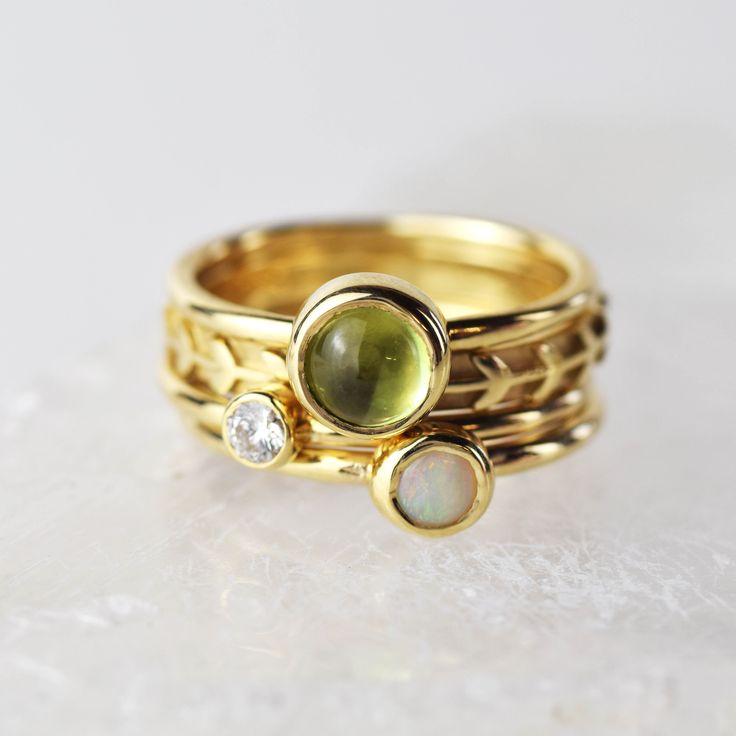 A stunning green peridot stacking ring made from solid 9ct yellow gold. Choose to wear the ring on its own, or mix and match it with other stacking rings from the Nebula collection, or why not add a sparkling Andromeda diamond ring? Peridot is a beautiful juicy green gemstone and the birthstone of August. It is one of only a few stones to come in only one colour, a lovely olive green and is said to bring a wonderful year to whoever wears it. It's warm glowing colour is a reminder of summer and o Yellow Gold Stackable Opal Ring For Promise, Stackable Green Diamond Ring In 14k Gold, Dainty Yellow Gold Stackable Opal Ring, Stackable Yellow Gold Peridot Jewelry, Gold Peridot Diamond Ring For May Birthstone, Yellow Gold Peridot Diamond Ring With Birthstone, Fine Jewelry Yellow Gold Stackable Rings For May Birthstone, Yellow Gold Peridot Stackable Rings, Stackable Peridot Promise Ring