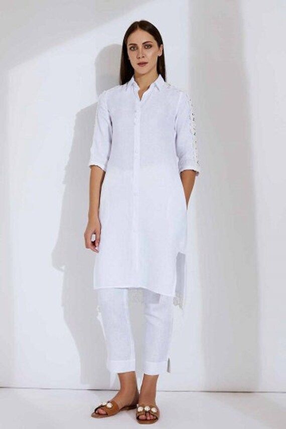 Super relaxed, soft as a feather, and incredibly glamorous - the Alora Linen kurta is an absolute dream and you'll look like one too when you step out wearing it! Made with linen/lace, it comes in white or maroon and features lace patches from shoulder to sleeve. The buttons are woven with crochet. The Alora LInen kurta radiates an ethereal appeal while ensuring you stay comfortable as ever! Model : Eduarda Height : 5Ft 8in  Wearing : XS Size Dress Fabric : 100% Linen Characteristics of Linen :  Hygroscopic All Natural UV Protection Kind On Skin Naturally Breathable Strong Improves With Age Handmade With Love In India By Yell Retail India. Price is Inclusive of All taxes. Elegant White Linen Kurta, Fitted White Bohemian Kurta, White Linen Kurta With Resham Embroidery, White Khadi Kurta, White Linen Fitted Kurta, Nehru Jackets, Linen Jacket, Pure Linen, Linen Clothes