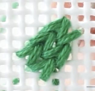 the green thread is being used to make an ornament