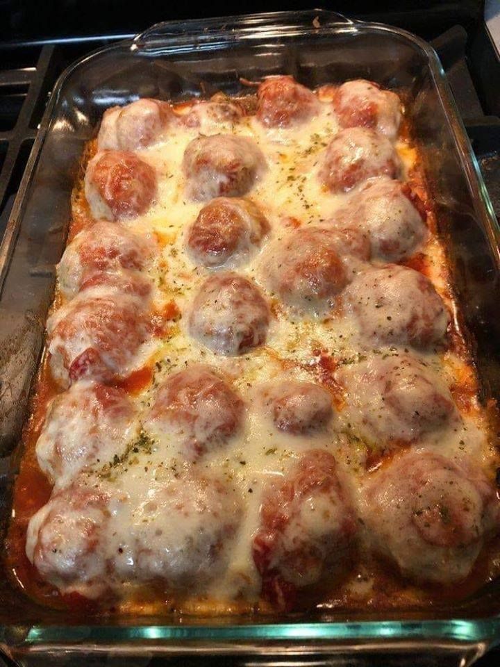 a casserole dish covered in meatballs and cheese