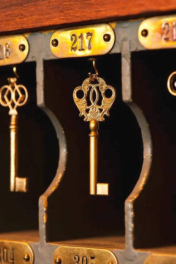 the keys are attached to the metal lock on the cabinet door, which is decorated with gold and silver numbers