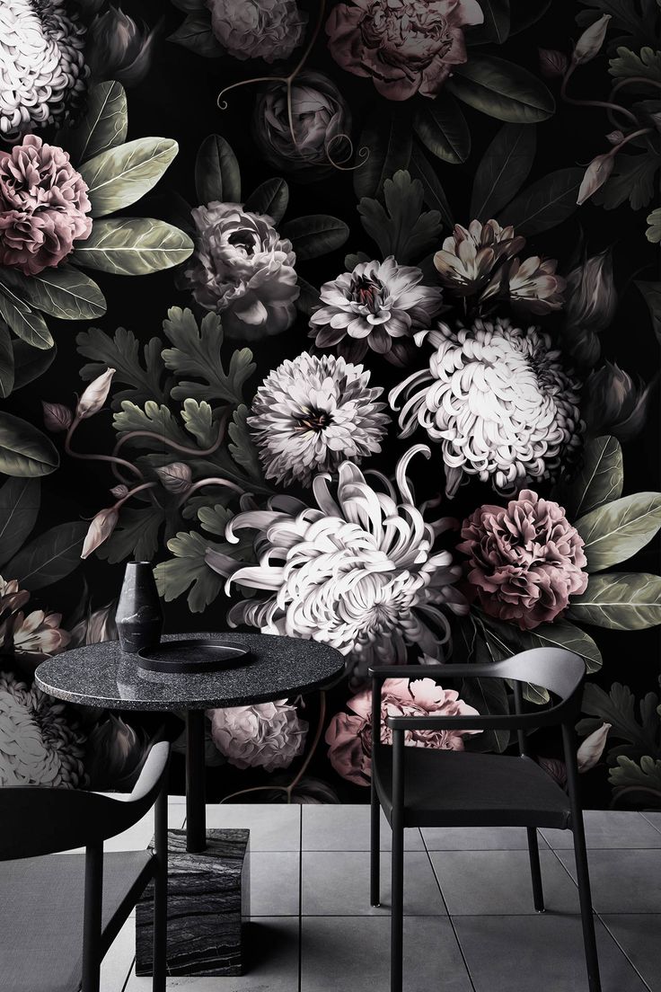 a black and white floral wallpaper with pink flowers on the back ground, next to two chairs