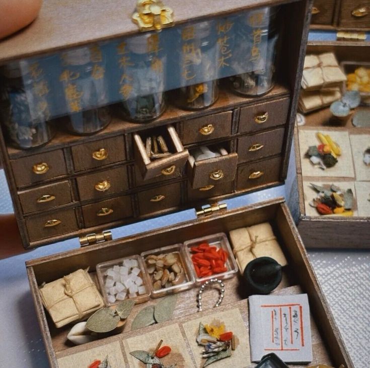 an open wooden box filled with lots of jewelry and other items on top of a table