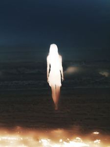 a person standing in the middle of a field at night