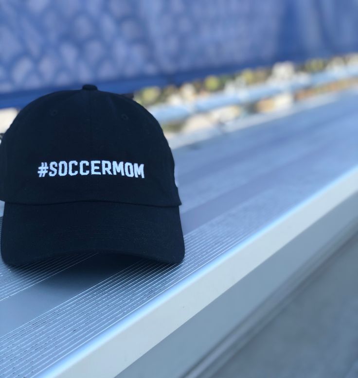 "Combining classic style and love of sport, our Soccer Mom Hat is the perfect accessory for the Sports Mom on the go. Rock your Soccer Mom hat to the game, during your workout or with your favorite Sports Mom outfit. Available in Black and Navy with White Embroidered lettering  * 100% chino cotton twill  * Unstructured, 6-panel, low-profile  * 3 ⅛\" crown  * Adjustable strap with antique buckle  * Head circumference: 20 ½\" - 21 ⅝\"" Sports Mom Outfit, Baseball Mom Hat, Bridal Party Hats, Mom On The Go, Mom Hat, Mom Outfit, Mom Hats, Mom Hoodies, Soccer Coaching