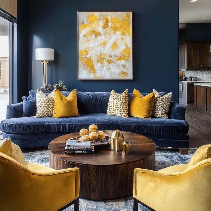 a living room filled with blue couches and yellow accented chairs in front of a painting