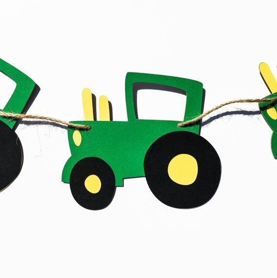 a green toy tractor hanging from a string on a white background with yellow and black wheels