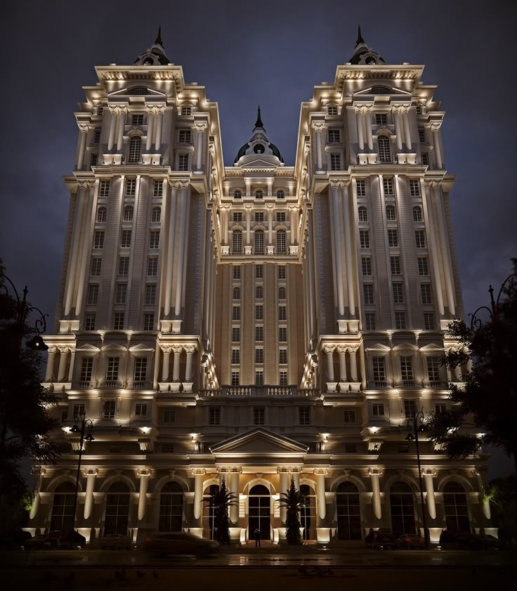 a large building lit up at night with lights on it's sides and windows