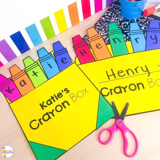 two children's crayon books with scissors on the table next to them