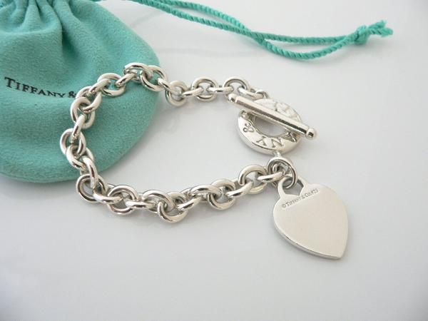 Overview:Offered for sale is a wonderful and gorgeous Tiffany & Co. Sterling Silver Heart Toggle bracelet.  Definitely a Tiffany piece that you will get your money's value for.  It works perfectly with pretty much any attire your put on, AND is a great statement piece.  The chain for this specific bracelet is quite substantial, and the pretty Tiffany heart just goes perfectly with it.   It is the perfect bracelet that fits a lifestyle on the go -- can be worn to pretty much any occasion! Sterling Silver Tiffany, Sterling Silver Bracelets Women Tiffany & Co., Pink Tiffany And Co Charms, Tiffany Charm Bracelets Tiffany & Co., Tiffany Inspired Jewelry Sterling Silver, White Gold Jewelry With Clasp For Gift, Luxury Heart Bracelet As A Gift, White Gold Bracelets With Clasp, Luxury Sterling Silver Heart Bracelet For Gift