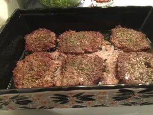 several hamburger patties are in a black tray