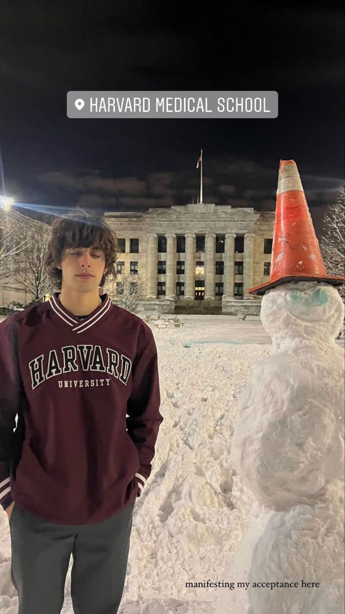 a young man standing next to a snowman in front of a building with a sign that says harvard medical school