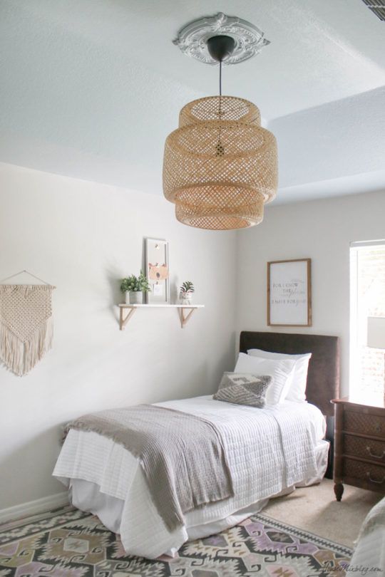 a bedroom with a bed, dresser and hanging basket light fixture in the middle of the room