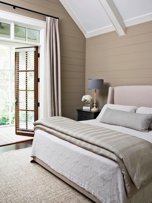 a bedroom with a large bed and sliding glass doors leading to an outside deck area