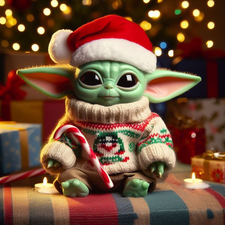 a baby yoda toy sitting on top of a table next to a christmas tree