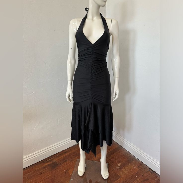 a mannequin wearing a black dress on a wooden floor