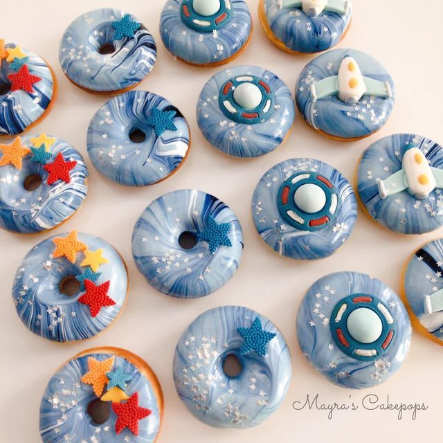 there are many donuts decorated with blue icing and stars on them, all in different designs