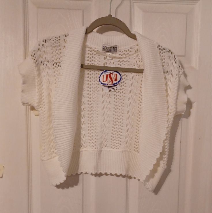 a white sweater hanging on a door hanger