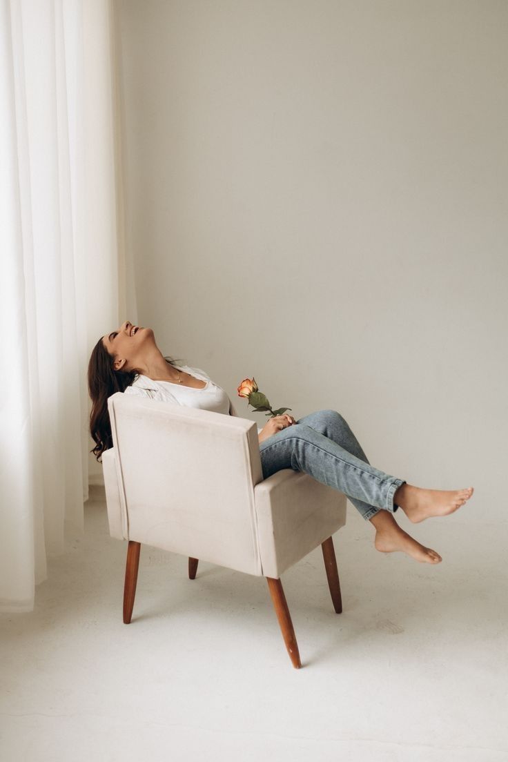 a woman laying on top of a white chair