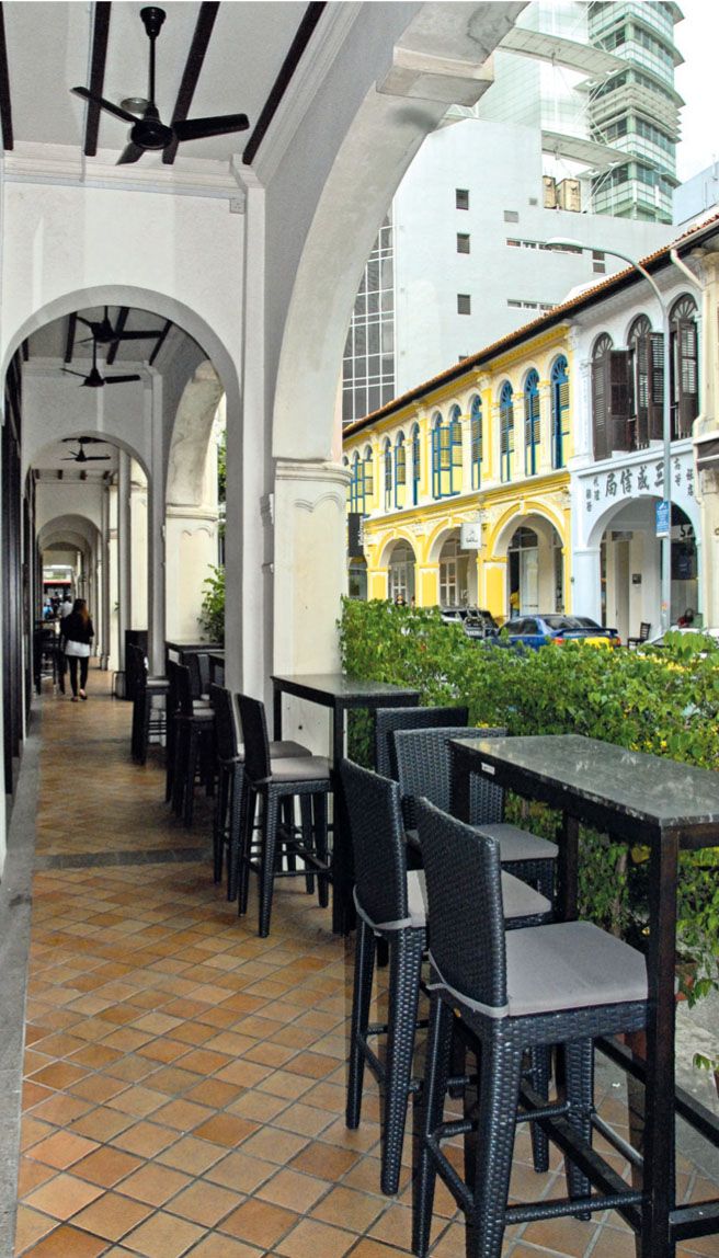 an outdoor restaurant with tables and chairs lined up along the side of the building,