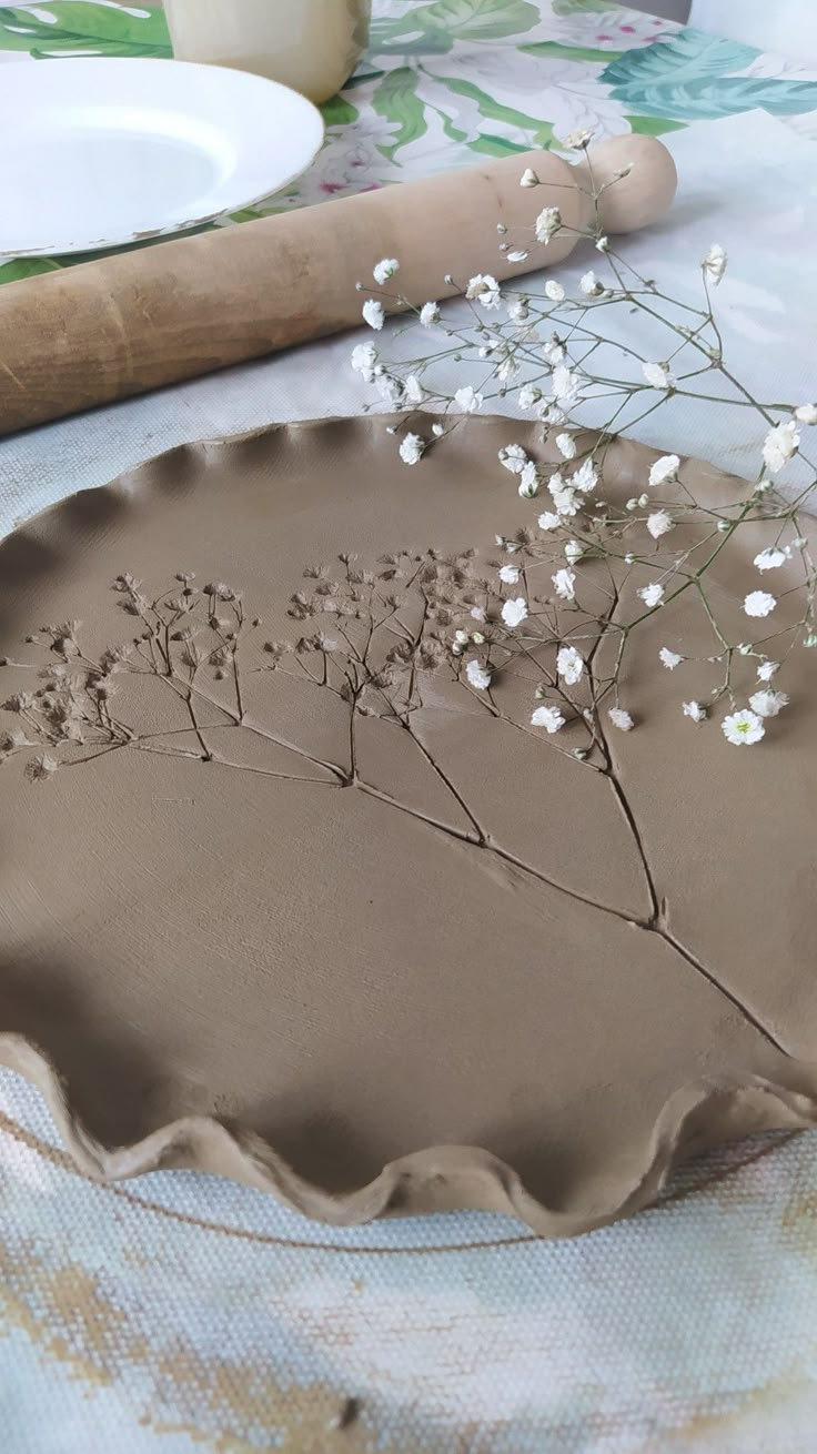 a cake with flowers on it sitting on top of a table next to a rolling pin