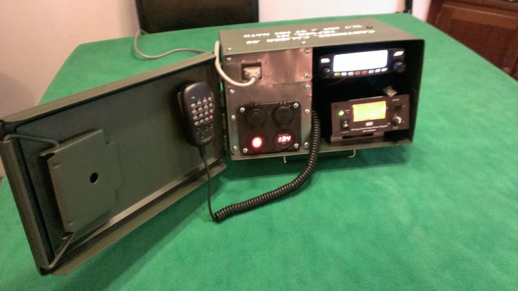 an old style radio sitting on top of a green table next to a cell phone