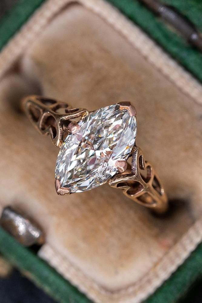 a ring with a diamond in it sitting on top of a green velvet box next to other jewelry items