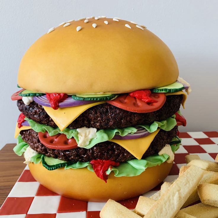 a large hamburger sitting on top of a table next to french fries