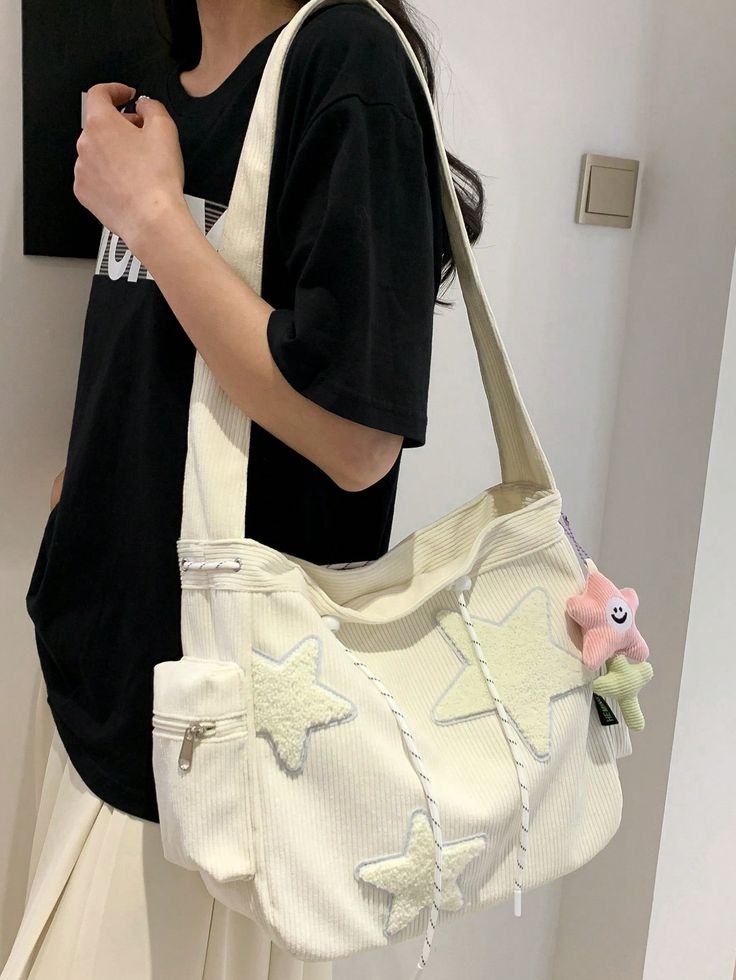 a woman holding a white bag with stars on it and a stuffed animal in the bottom