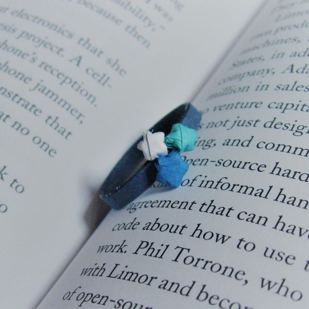 an origami ring sitting on top of an open book