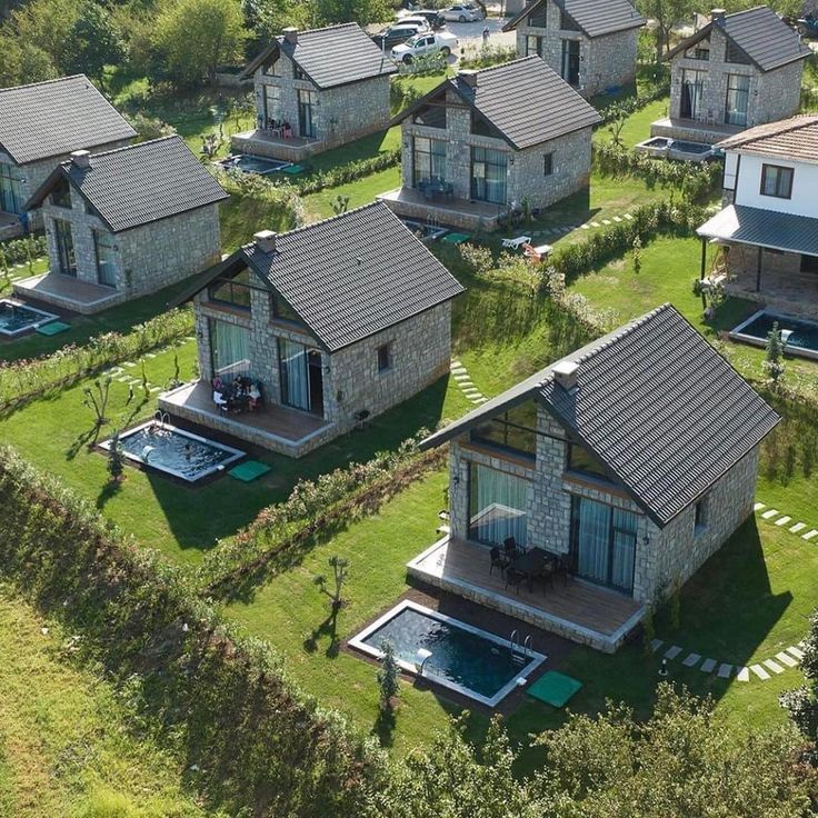 an aerial view of several houses with swimming pool and hot tubs in the yard