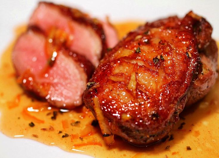 two pieces of meat sitting on top of a white plate