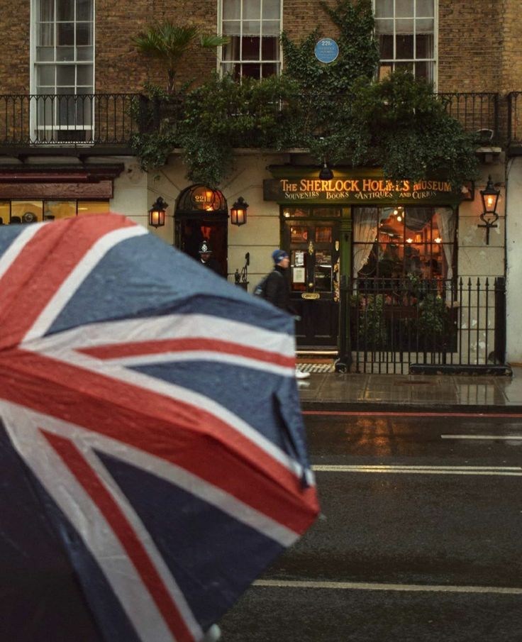 an open umbrella with the british flag on it is in front of a storefront