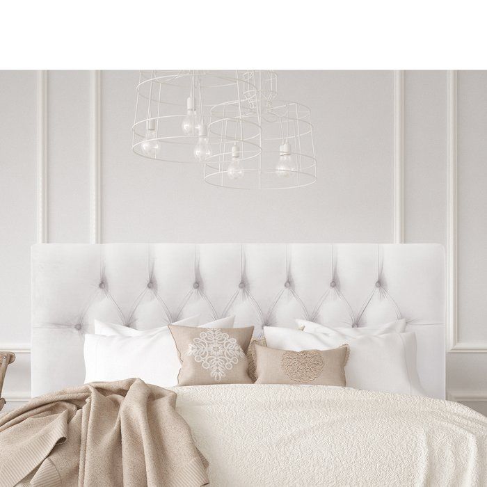 a white bed with pillows and blankets on it