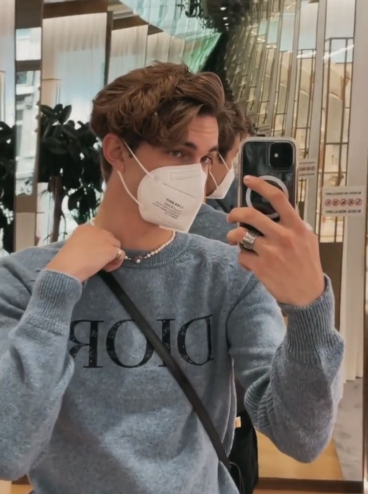 a man wearing a face mask taking a selfie