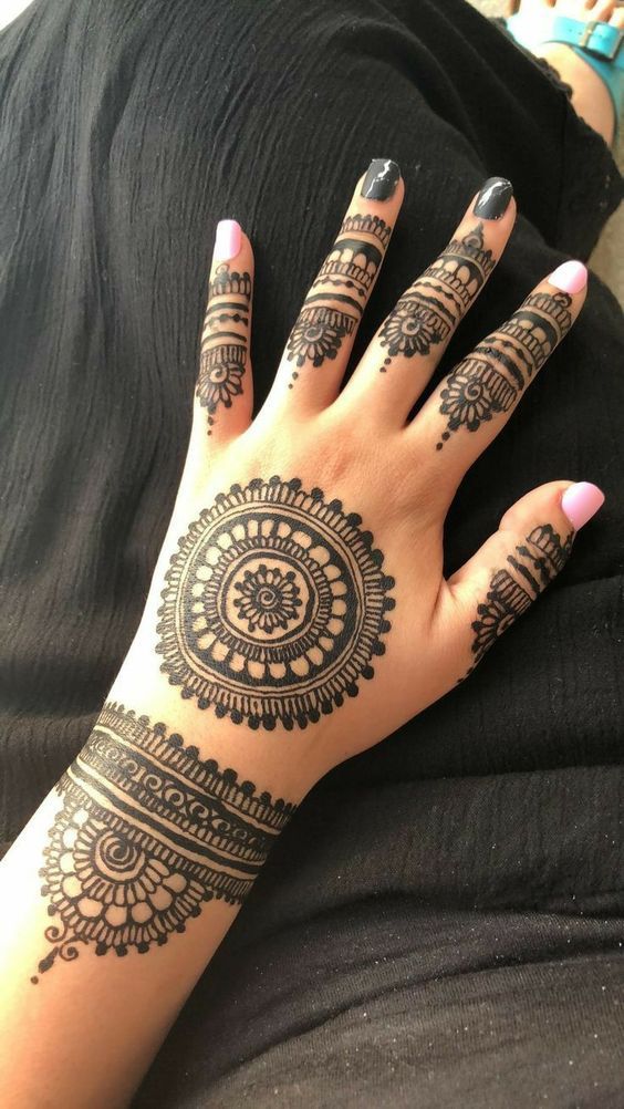 a woman's hand with henna tattoos on it