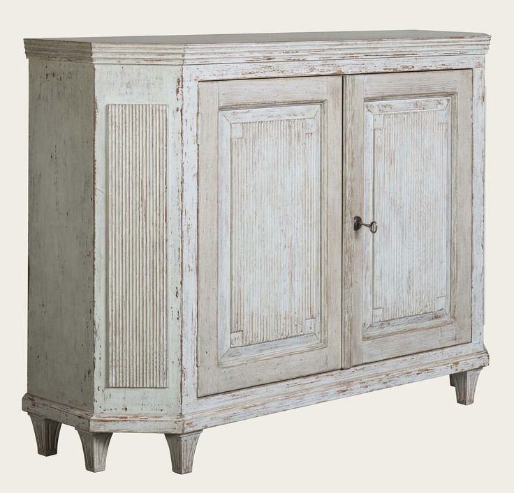 an old white cabinet with two doors