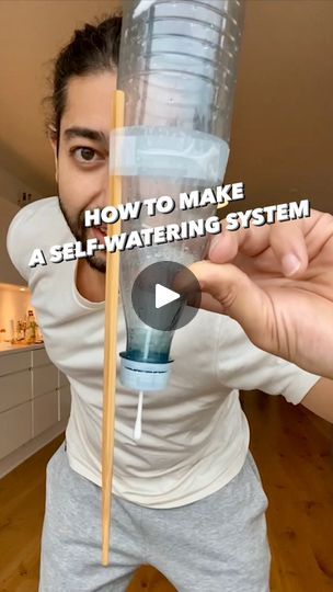 a man holding a plastic water bottle with a straw in it and the words how to make a self - watering system