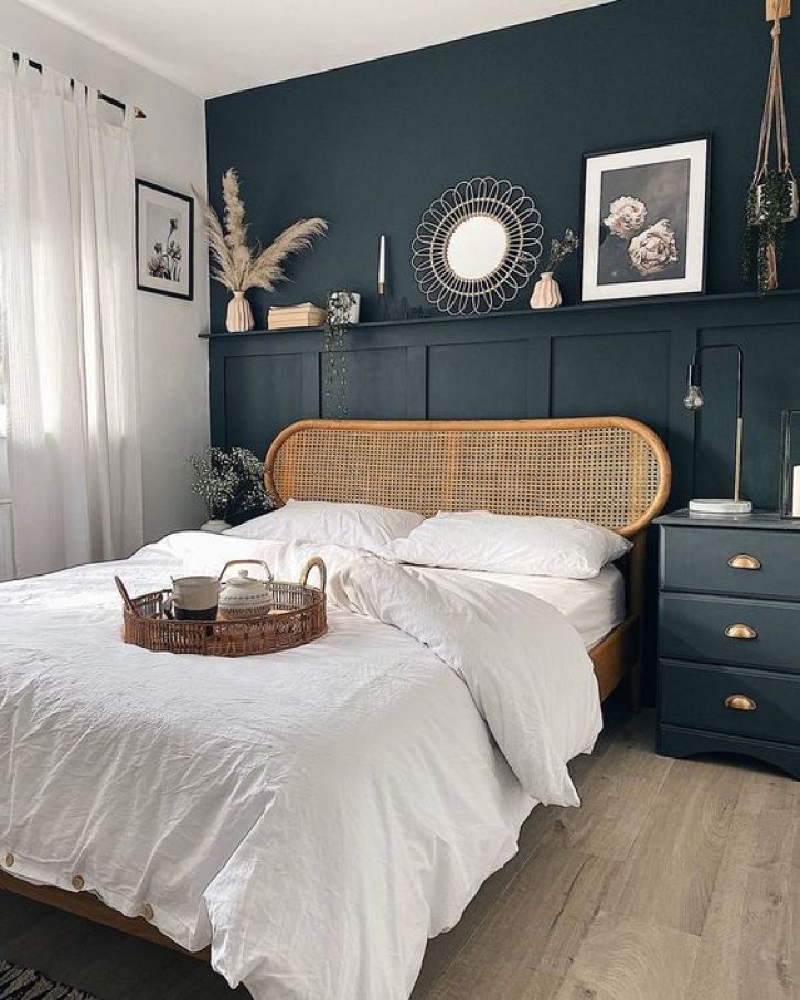 a bed with white linens and pillows in a bedroom next to a wooden dresser