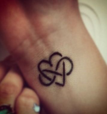 a small heart tattoo on the wrist