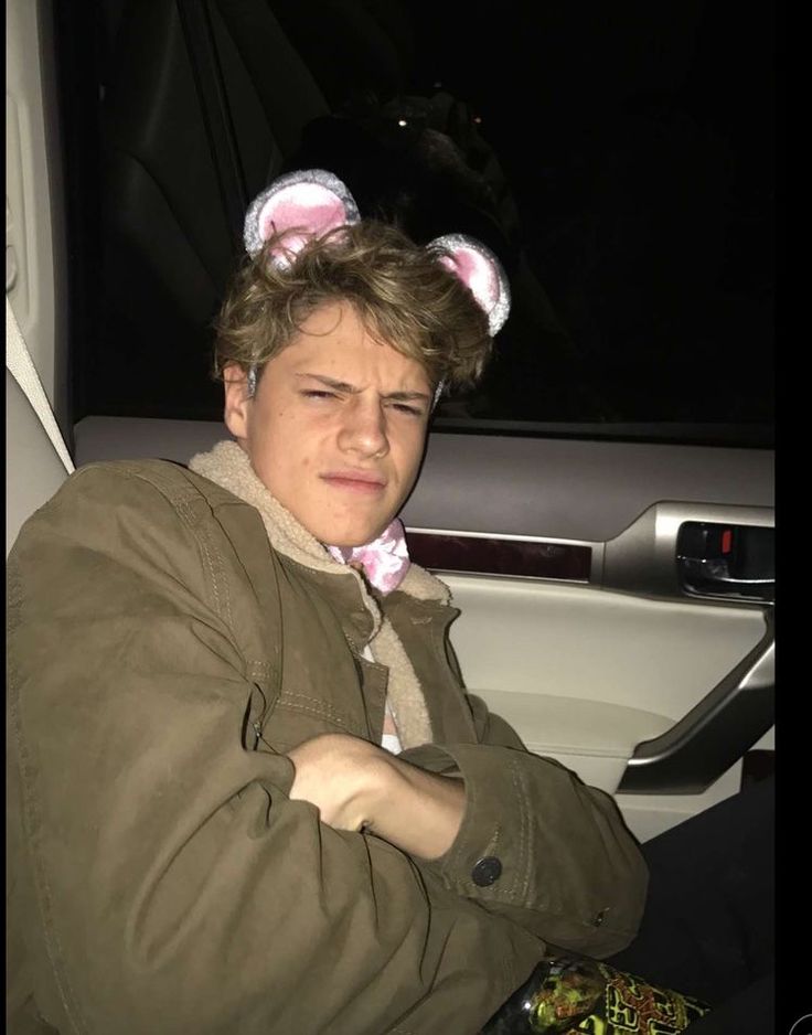 a man sitting in the back seat of a car wearing bunny ears