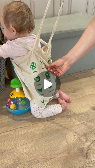 a baby sitting on the floor playing with a bag