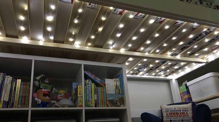 a room with bookshelves and lights on the ceiling