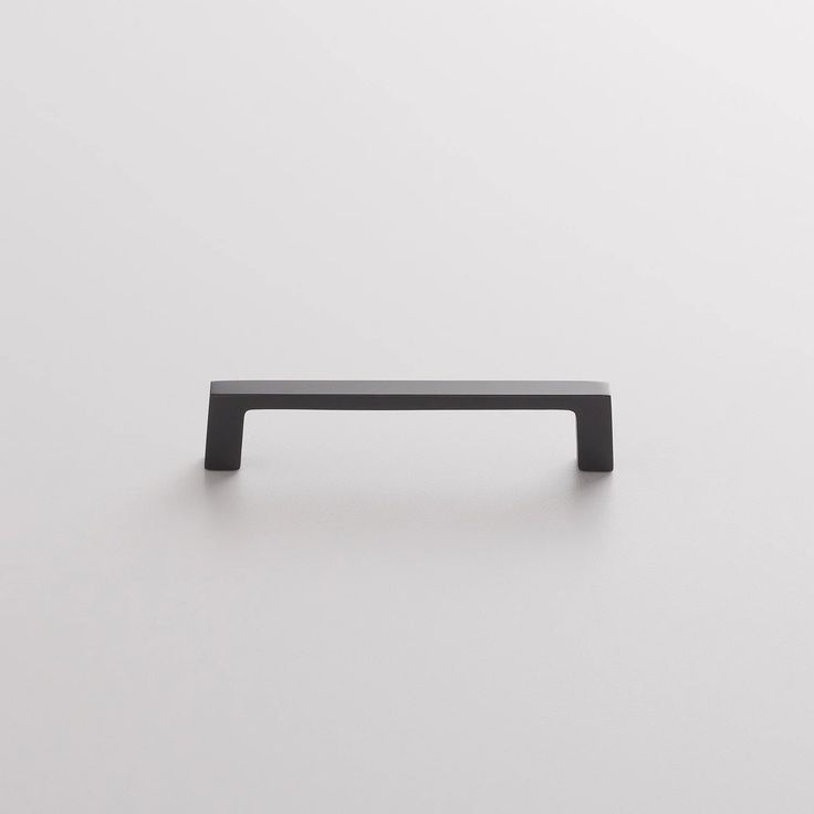 a black cabinet handle on a white surface with no one in it or someone else