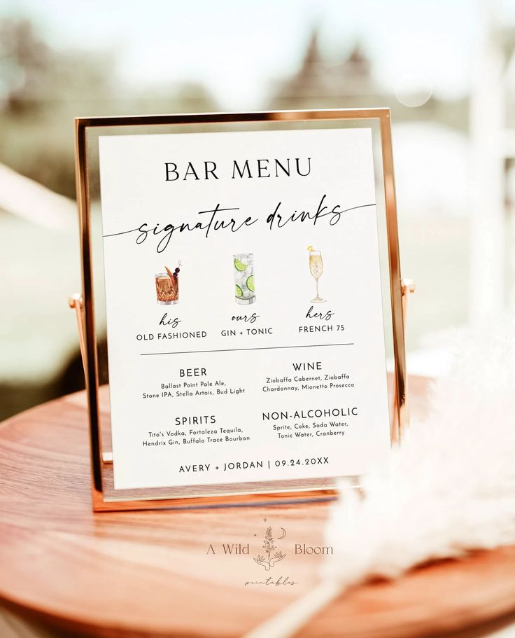 a menu card sitting on top of a wooden table next to a white feathers feather