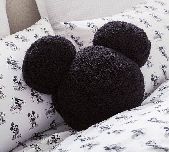 two black mickey mouse head pillows sitting on top of a bed