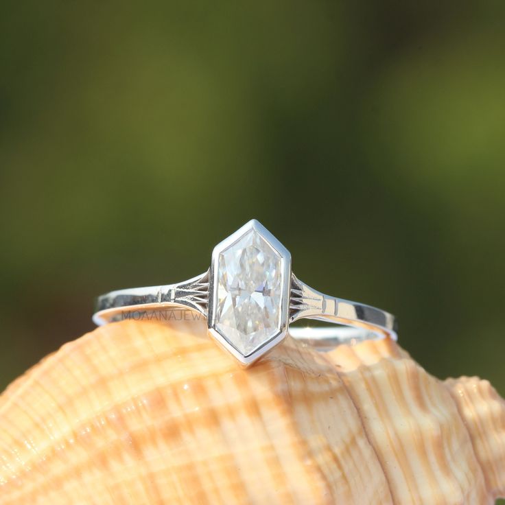 a diamond ring sitting on top of a shell