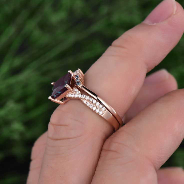 a woman's hand holding a ring with an amethorate and diamonds