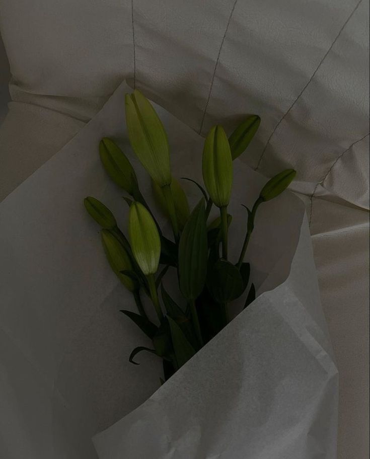 a bouquet of flowers is wrapped in white paper